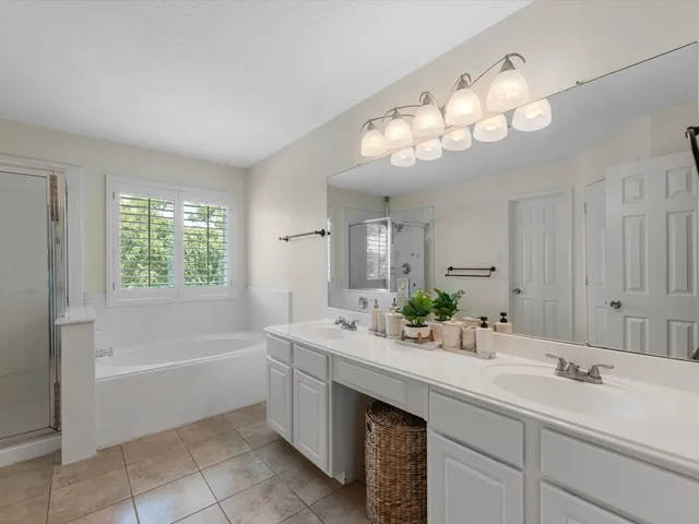 a bathroom with a sink double vanity mirror and a bathtub