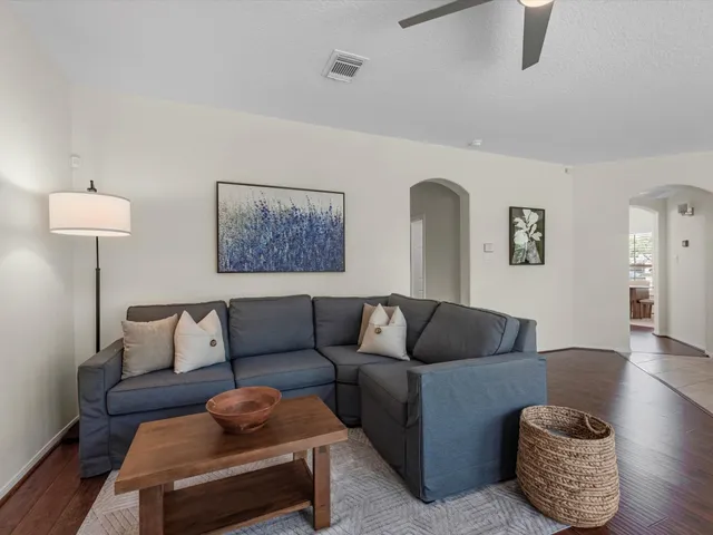 a living room with furniture and a wooden floor