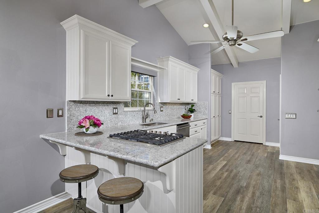 4235 Harrison Street Carlsbad, CA 92008 - Photo 11 of 55 a kitchen with stainless steel appliances granite countertop a sink cabinets and wooden floor