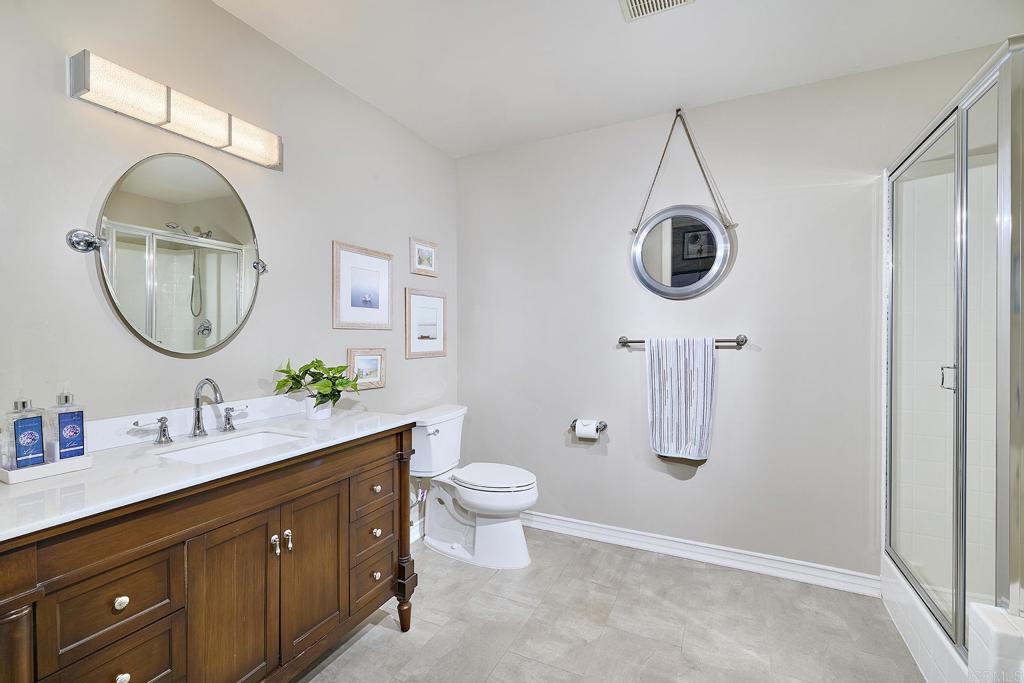 4235 Harrison Street Carlsbad, CA 92008 - Photo 30 of 55 a en suite bathroom with a granite countertop toilet sink and mirror
