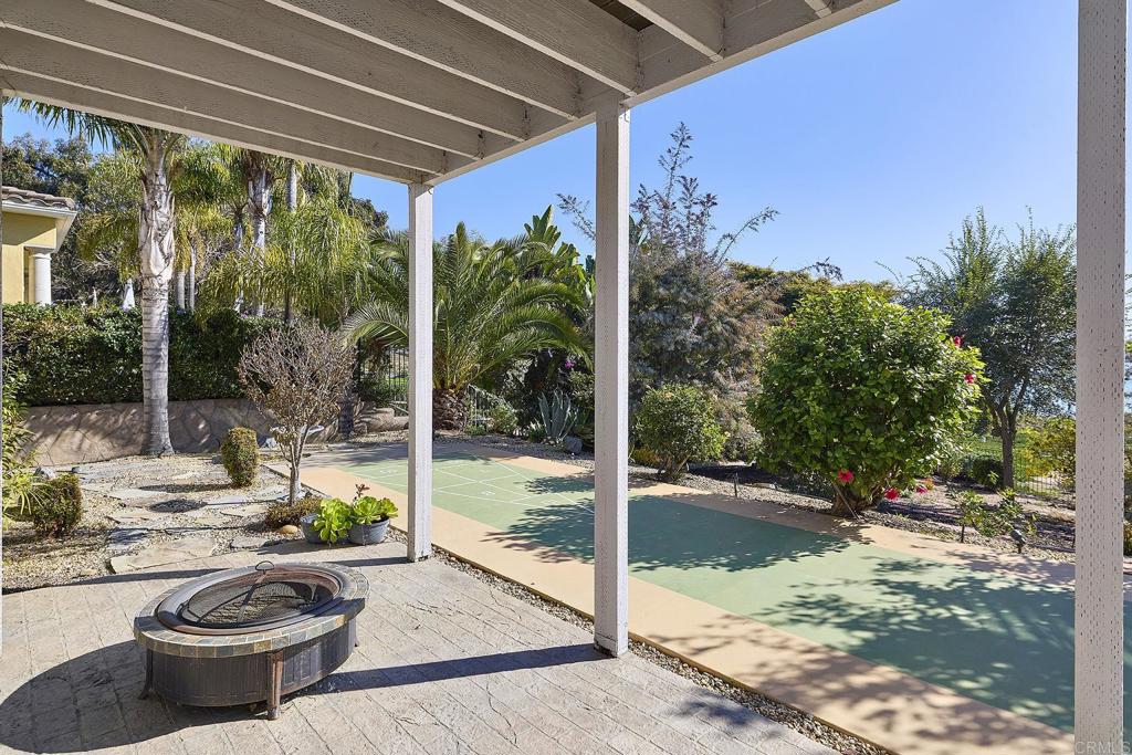 4235 Harrison Street Carlsbad, CA 92008 - Photo 36 of 55 a view of a patio with table and chairs potted plants and palm tree