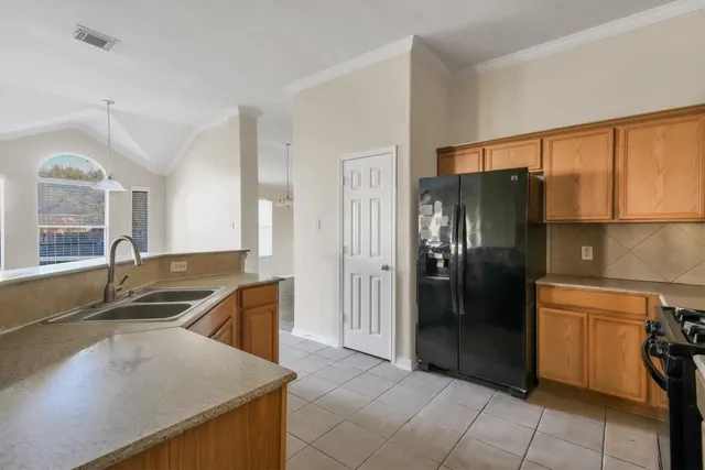 a kitchen with stainless steel appliances granite countertop a refrigerator a sink and a stove
