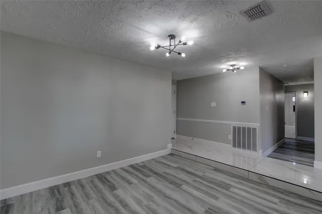 en empty room with stairs and wooden floor