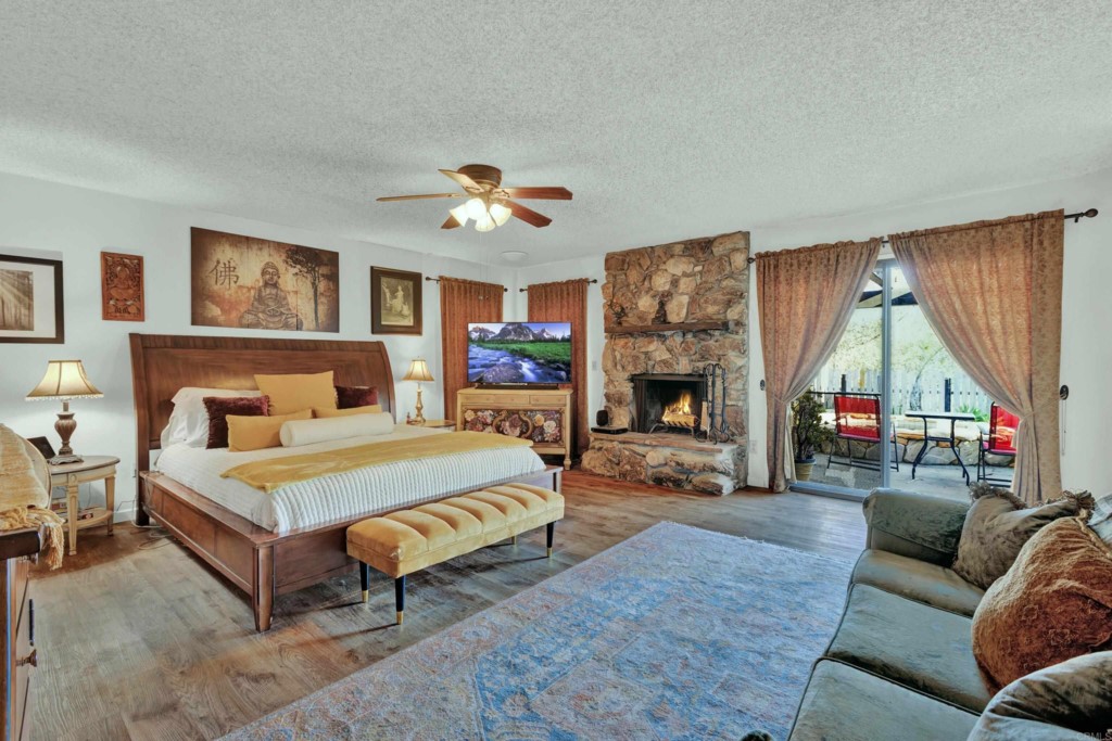 15866 Lyons Valley Road Jamul, CA 91935 - Photo 21 of 56 a spacious bedroom with a bed a couch and a fireplace