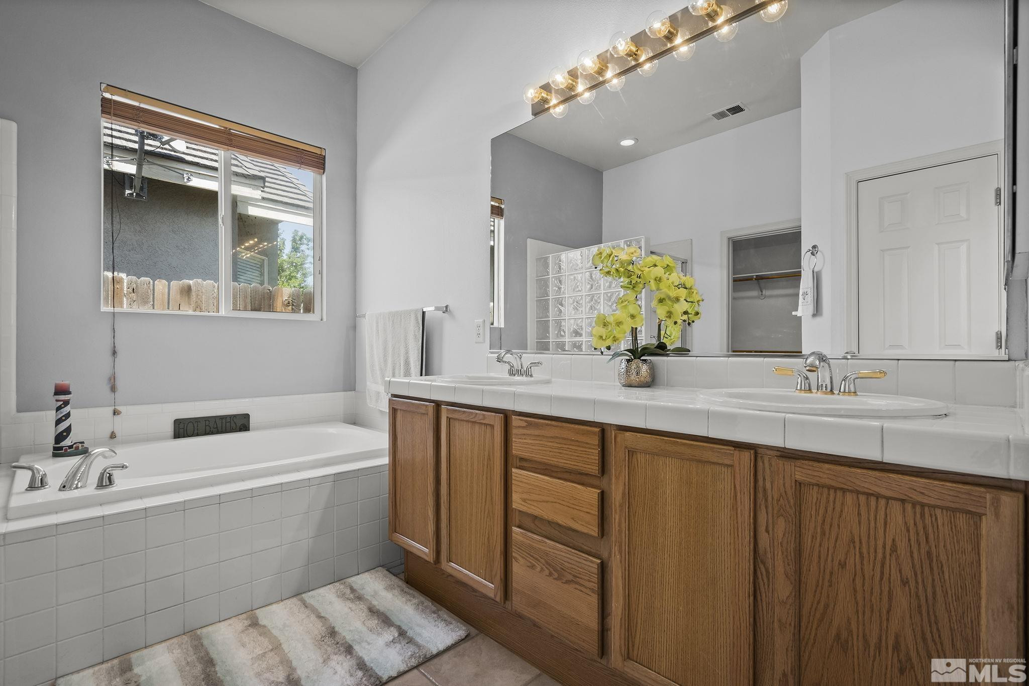 10160 Buckeye Court Reno, NV 89521 - Photo 17 of 36 a bathroom with a double vanity sink mirror and bathtub