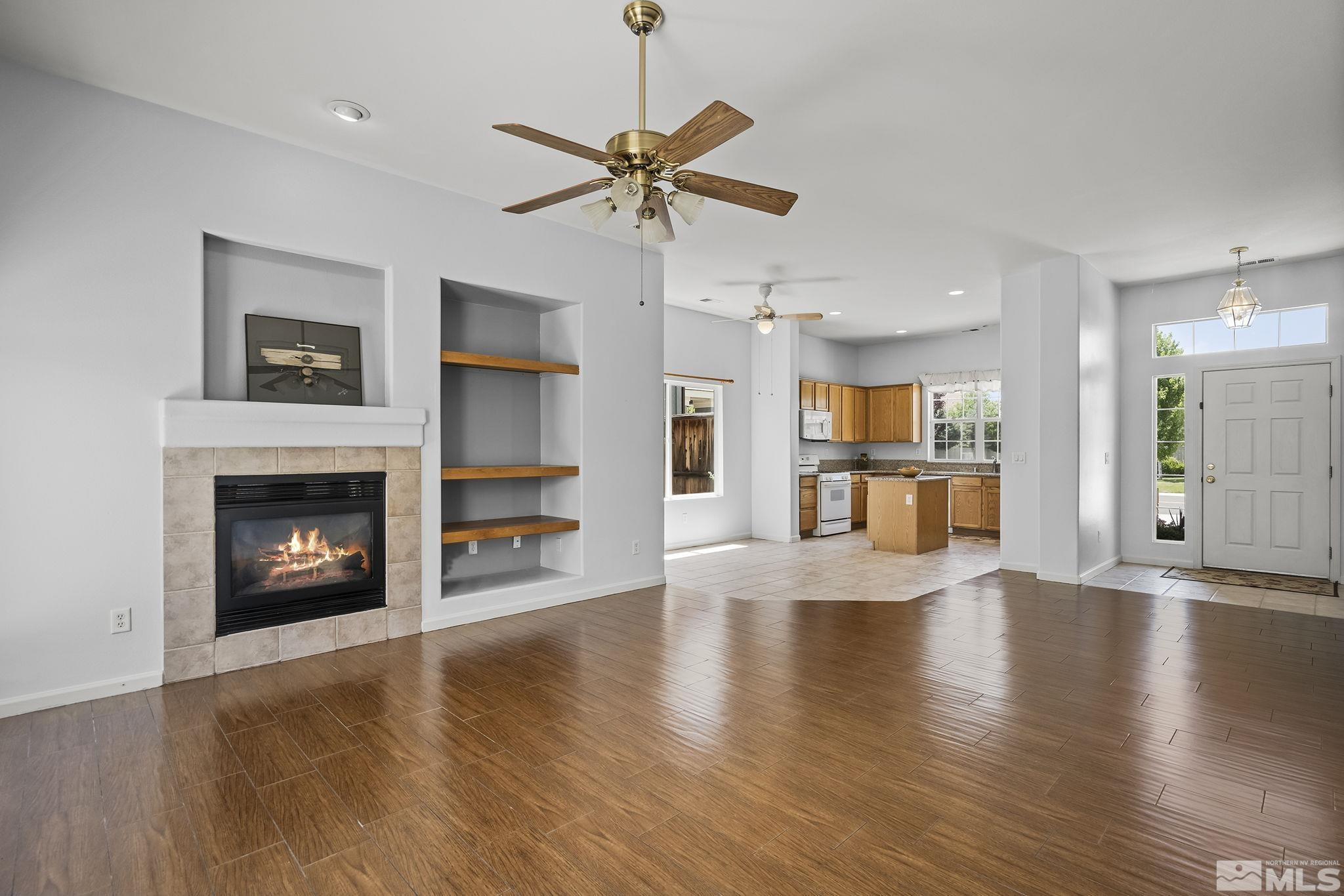 10160 Buckeye Court Reno, NV 89521 - Photo 4 of 36 a view of a room with wooden floor a ceiling fan and a kitchen