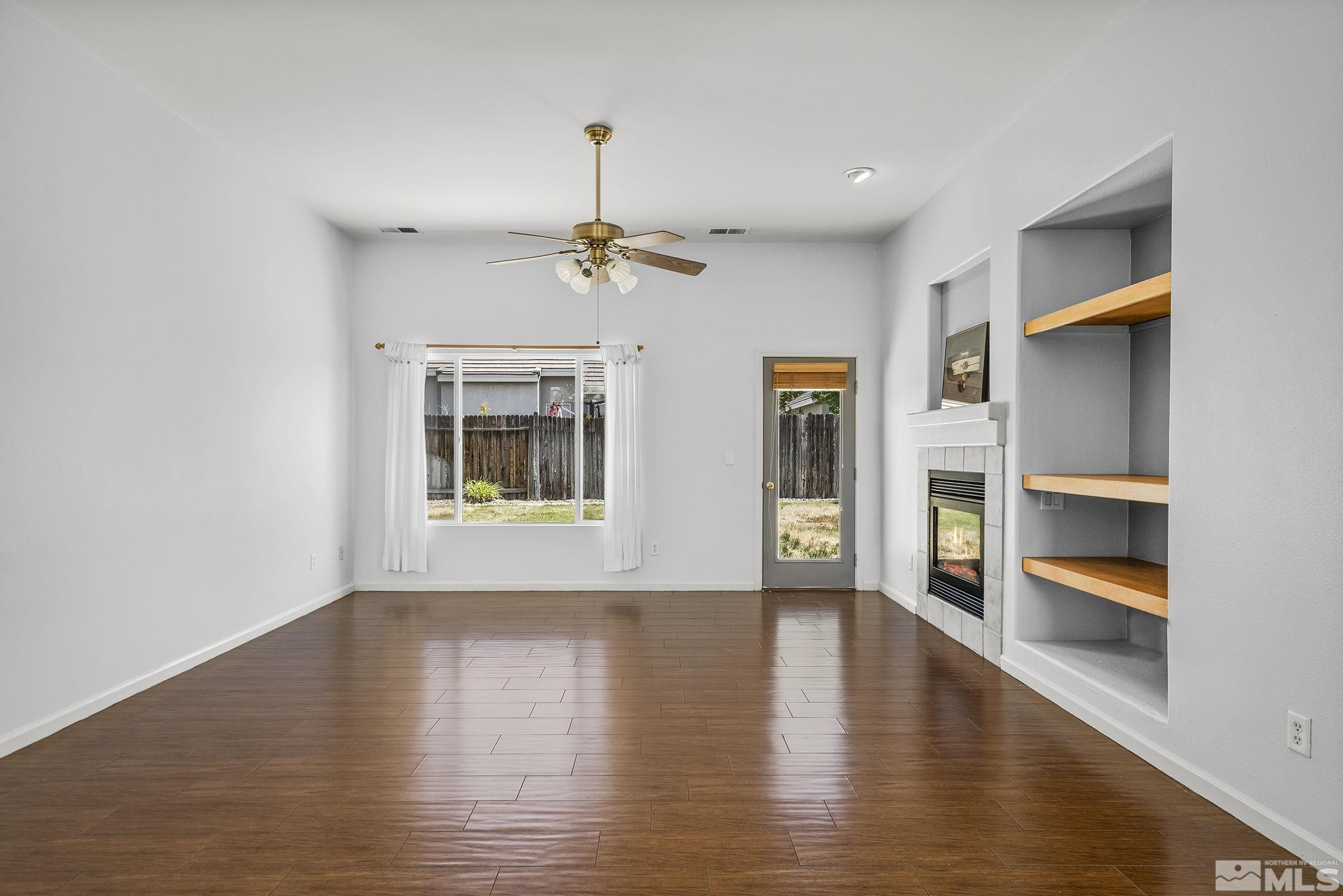 10160 Buckeye Court Reno, NV 89521 - Photo 5 of 36 a view of an empty room with a window and wooden floor