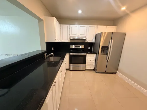 a kitchen with stainless steel appliances a refrigerator a sink a stove a microwave and cabinets