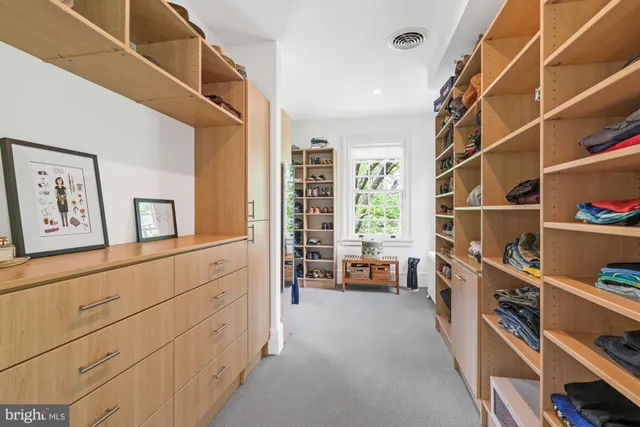 a view of walk in closet with clothes and shoes