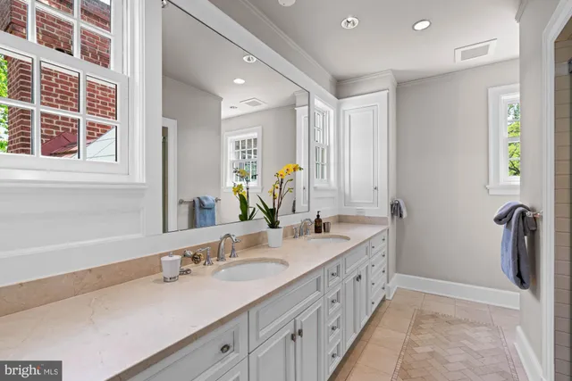 a bathroom with a double vanity sink a mirror and a bathtub