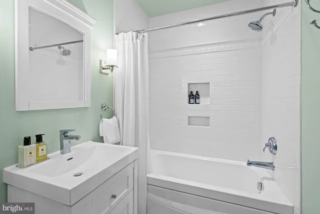 a bathroom with a tub a sink and a shower