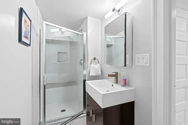 a bathroom with a sink mirror and shower