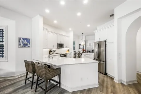 a kitchen with refrigerator and chairs