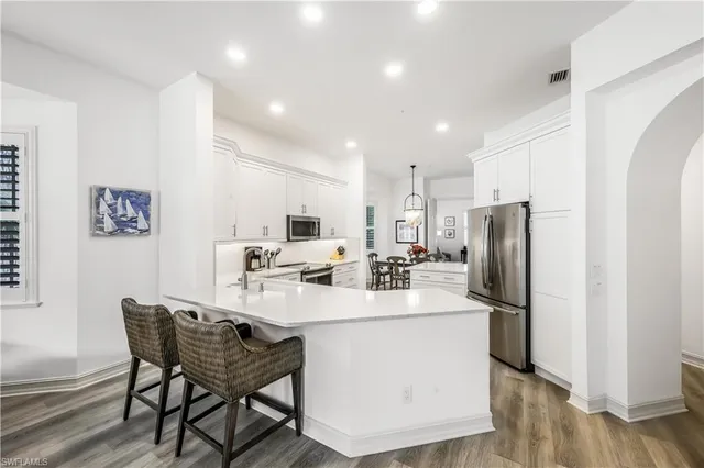 a kitchen with refrigerator and chairs