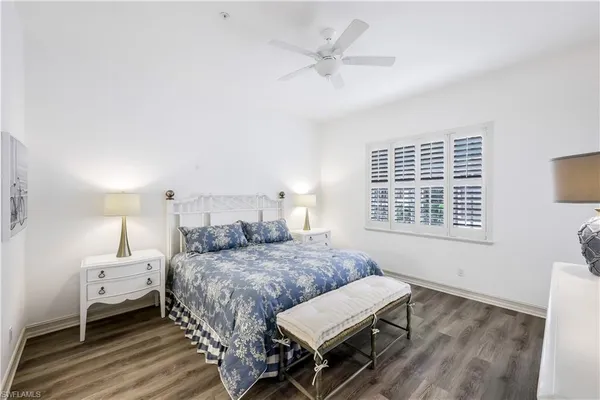 a bedroom with a bed a chandelier and a window