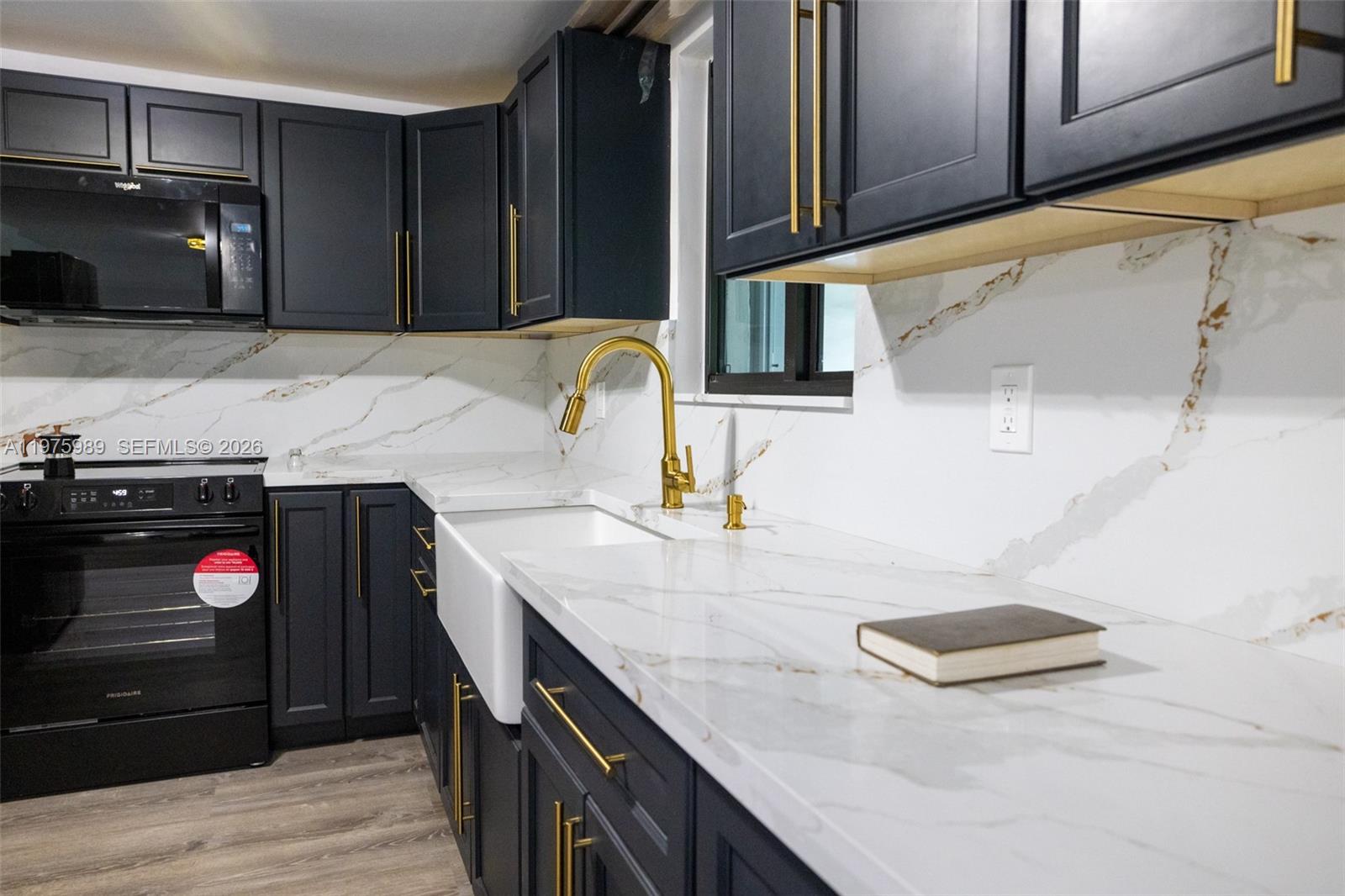 3401 Southwest 17th Street, Unit 3401 Miami, FL 33145 - Photo 18 of 69 a kitchen with a sink dishwasher a stove and a microwave oven with wooden floor