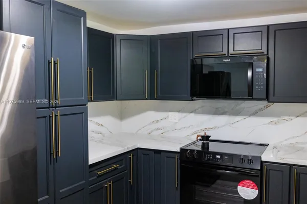 a view of an empty room with wooden floor and a ceiling fan