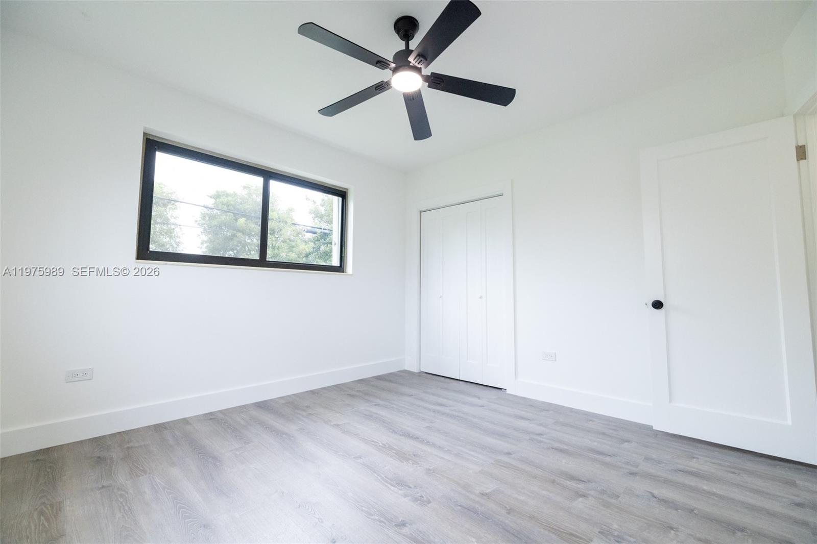 3401 Southwest 17th Street, Unit 3401 Miami, FL 33145 - Photo 30 of 69 an empty room with wooden floor ceiling fan and windows