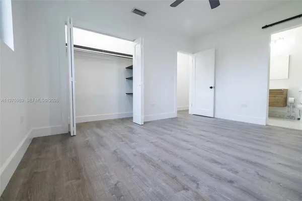 an empty room with a window and a ceiling fan