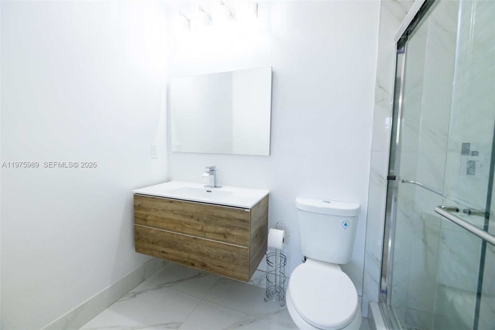 3401 Southwest 17th Street, Unit 3401 Miami, FL 33145 - Photo 39 of 69 a bathroom with a sink a toilet and a mirror