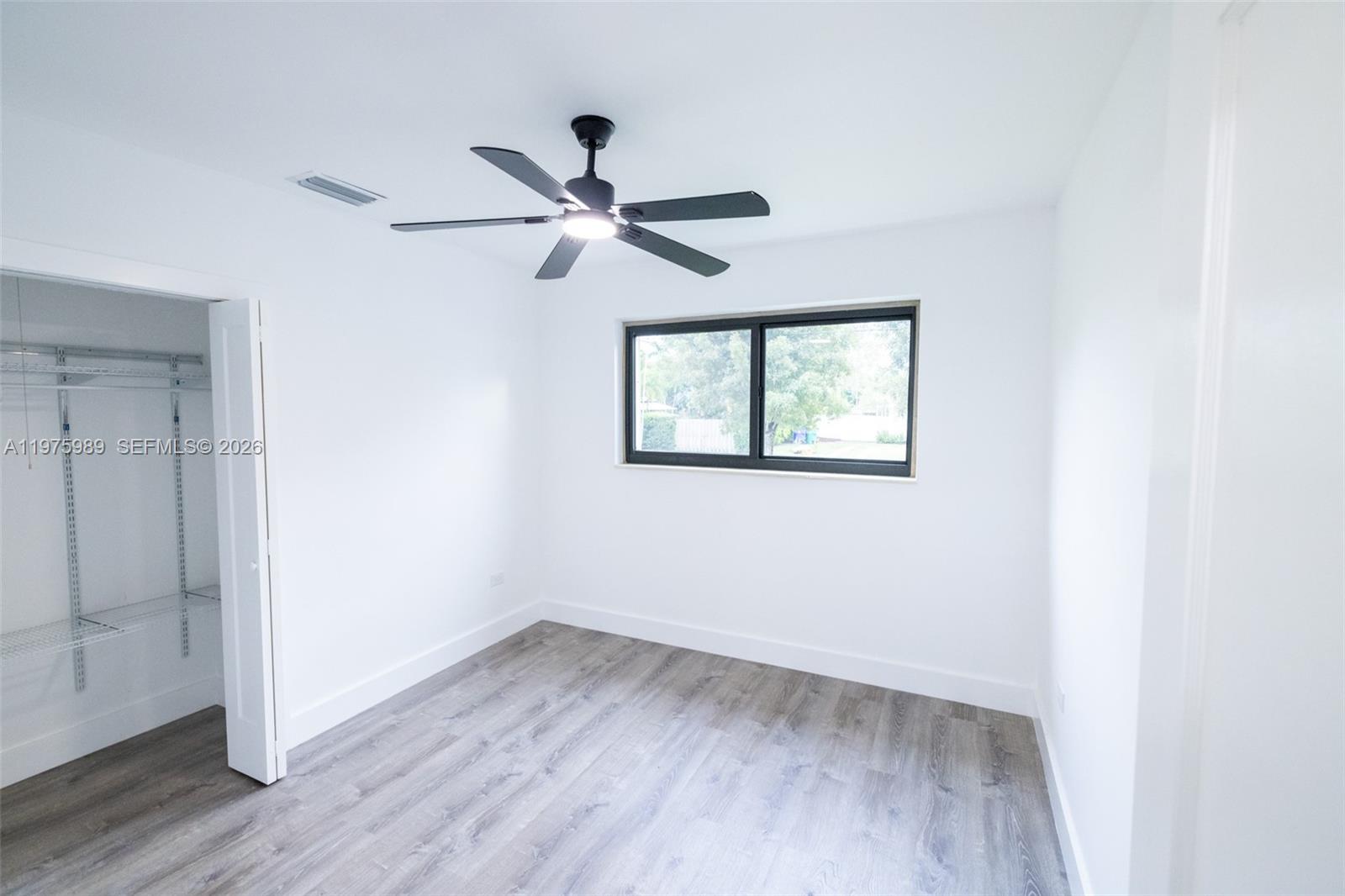 3401 Southwest 17th Street, Unit 3401 Miami, FL 33145 - Photo 51 of 69 an empty room with wooden floor fan and windows