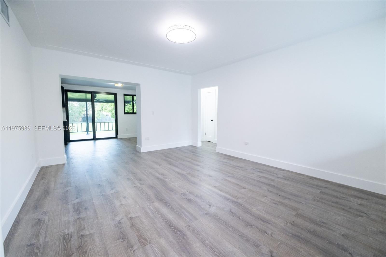 3401 Southwest 17th Street, Unit 3401 Miami, FL 33145 - Photo 60 of 69 a view of an empty room with wooden floor and a window