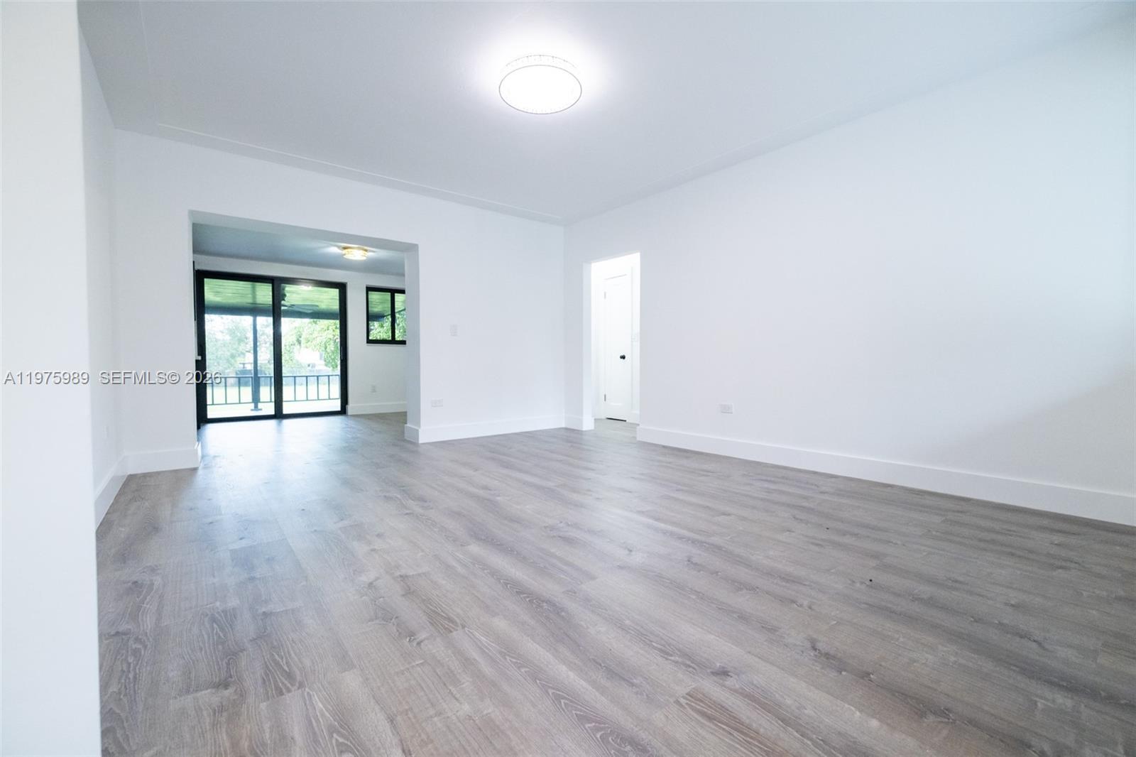 3401 Southwest 17th Street, Unit 3401 Miami, FL 33145 - Photo 61 of 69 a view of an empty room with wooden floor and a window
