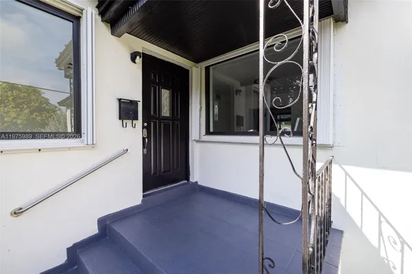 a view of a house with a yard and potted plants