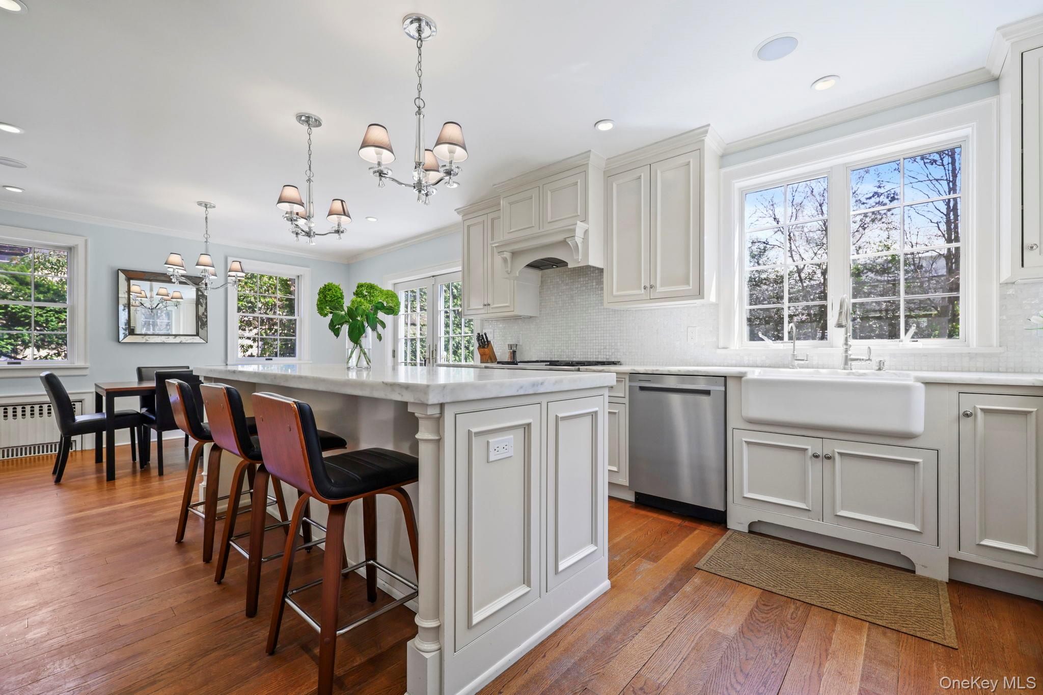 134 Brewster Road Scarsdale, NY 10583 - Photo 11 of 37 a kitchen with kitchen island granite countertop a stove a sink a dining table and chairs with wooden floor