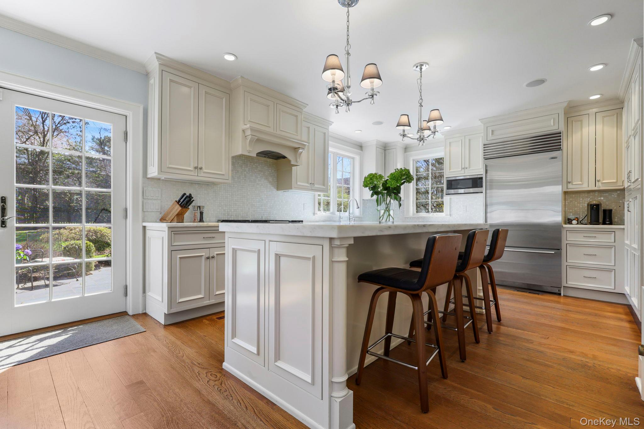 134 Brewster Road Scarsdale, NY 10583 - Photo 12 of 37 a kitchen with stainless steel appliances kitchen island granite countertop a table chairs and a wooden floors
