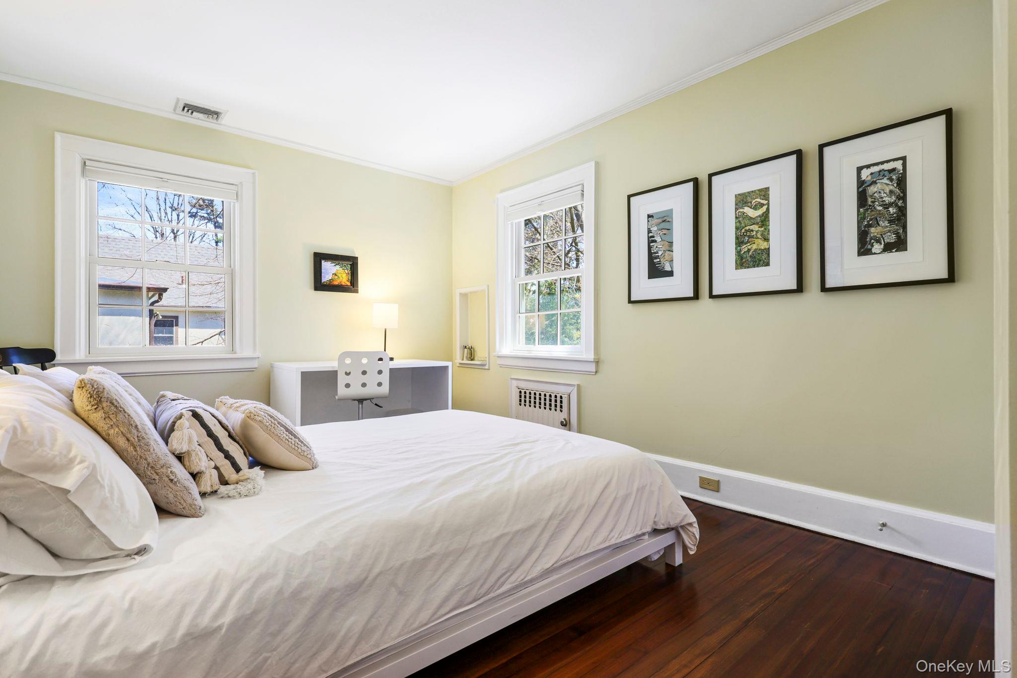 134 Brewster Road Scarsdale, NY 10583 - Photo 21 of 37 a bedroom with bed and wall painting with wooden floor