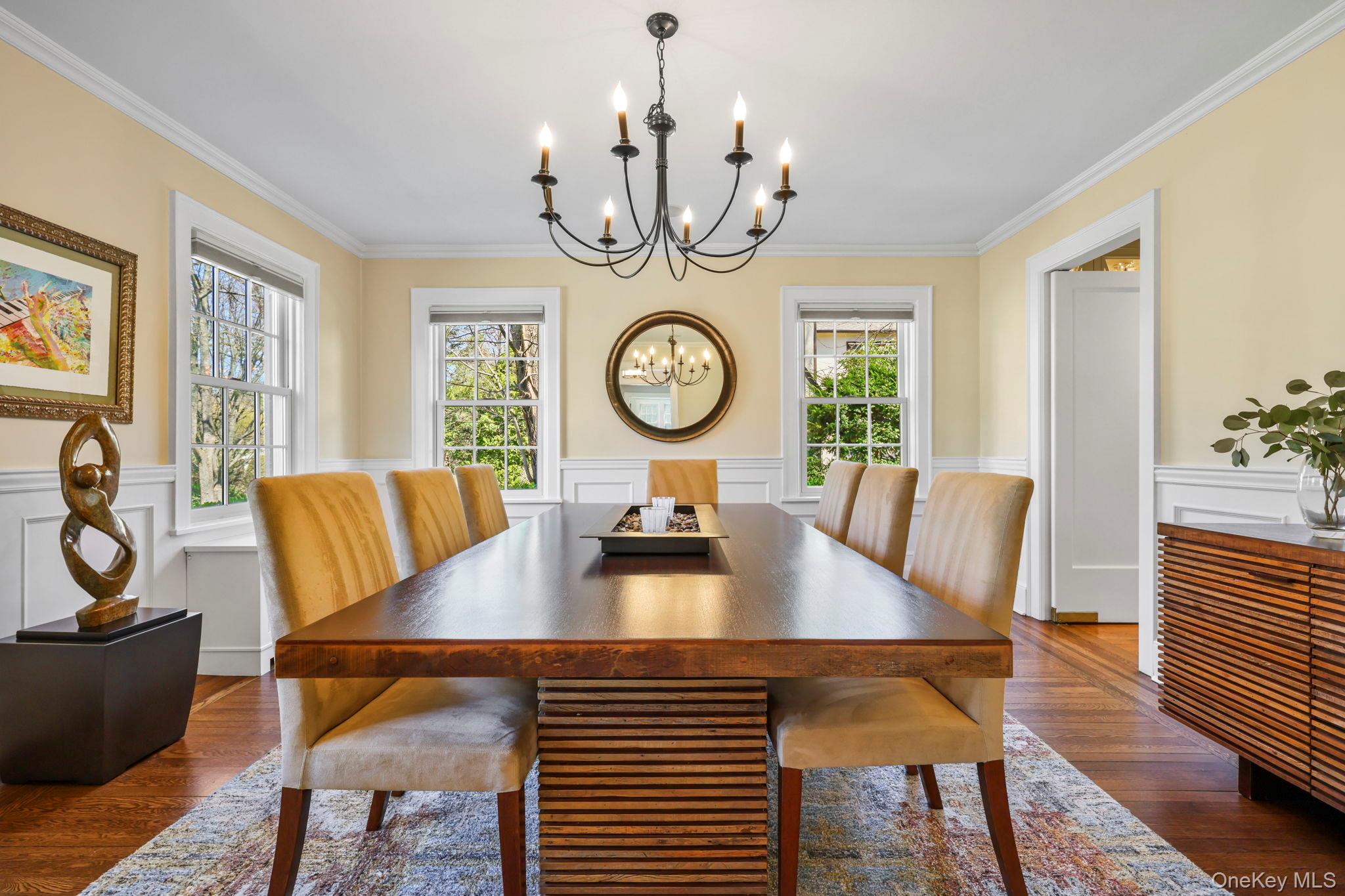 134 Brewster Road Scarsdale, NY 10583 - Photo 4 of 37 a view of a dining room with furniture a chandelier and wooden floor