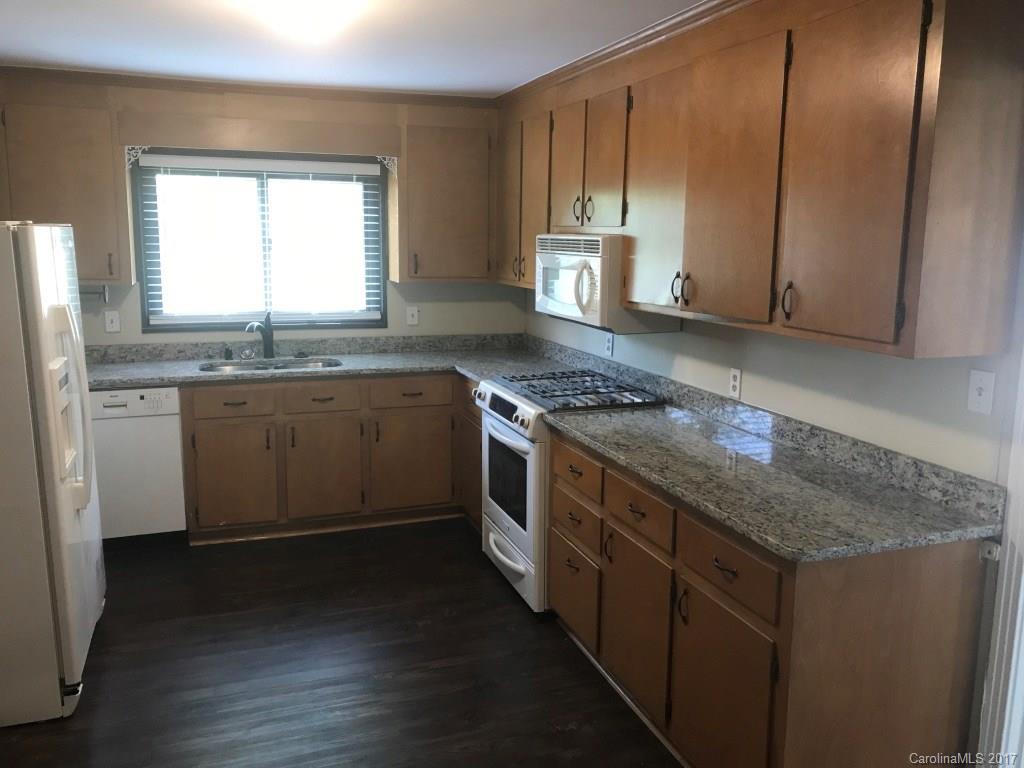 6561 Morehead Road Harrisburg, NC 28075 - Photo 6 of 24 a kitchen with stainless steel appliances granite countertop a stove a sink and a microwave