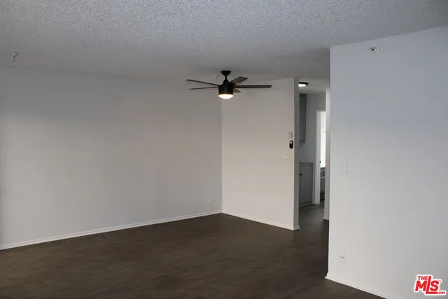 an empty room with a ceiling fan and carpet
