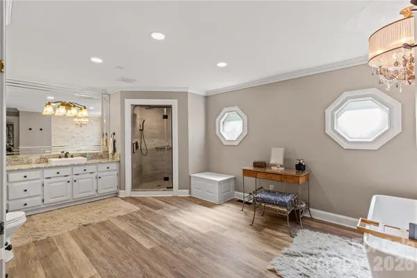 a spacious bedroom with a bed and a mirror on dresser