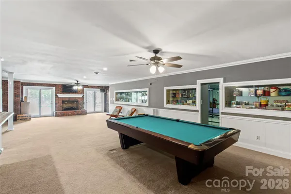 a living room with furniture pool table and rug
