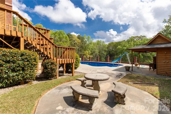 a view of a house with pool and chairs
