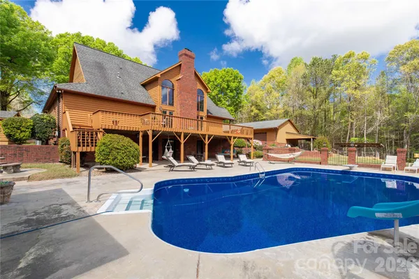 a view of a house with pool and sitting area
