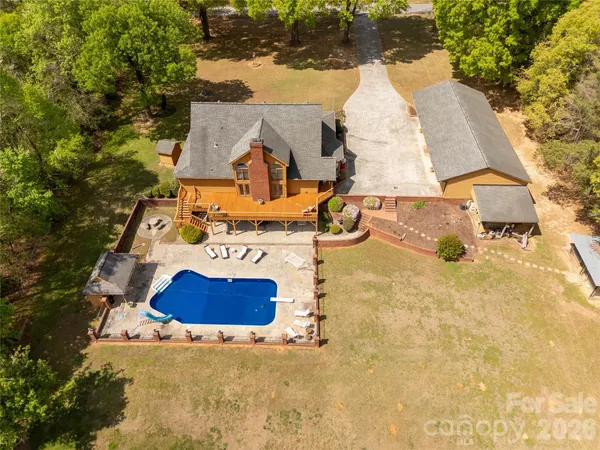 an aerial view of a house with swimming pool and porch