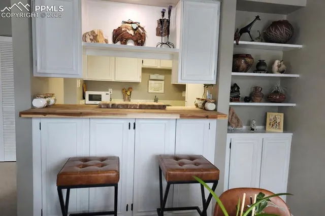 a kitchen with stainless steel appliances granite countertop a table chairs stove and cabinets