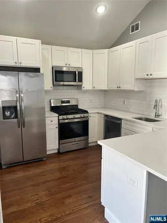 a kitchen with cabinets stainless steel appliances and a sink