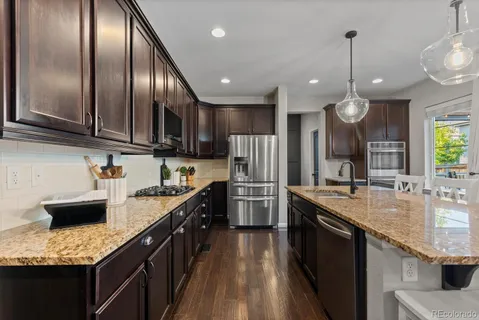 a kitchen with stainless steel appliances granite countertop a sink a stove and kitchen island
