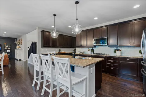 a kitchen with stainless steel appliances granite countertop a stove a sink a microwave a center island and a cabinets