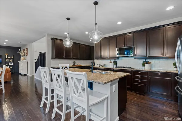 a kitchen with stainless steel appliances granite countertop a stove a sink a microwave a center island and a cabinets