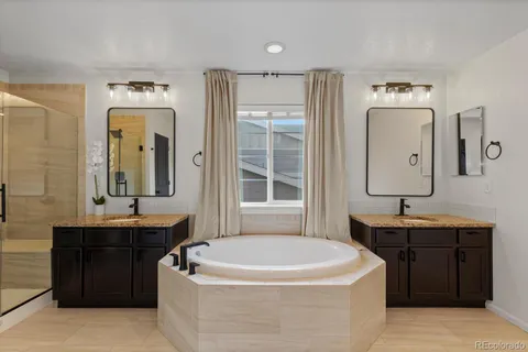 a spacious bathroom with a tub sink and mirror