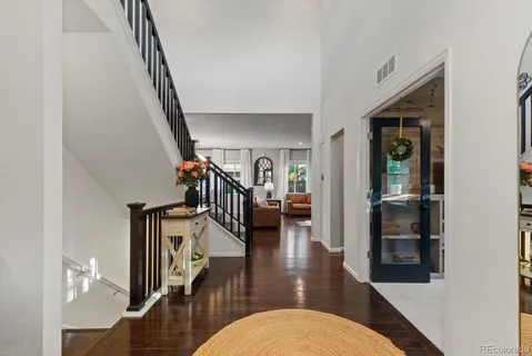 a hallway with wooden floor stairs and furniture