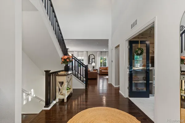a hallway with wooden floor stairs and furniture