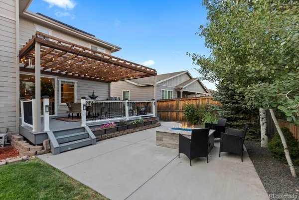 a patio with table and chairs and potted plants