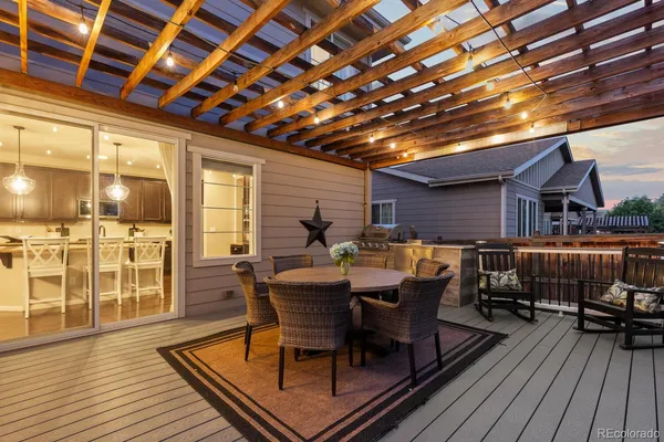 a view of a roof deck with table and chairs with wooden floor