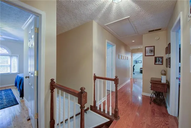 a bedroom with a bed a dresser and wooden floor